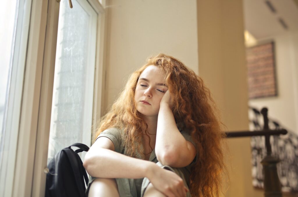 tired young woman in a school corridor